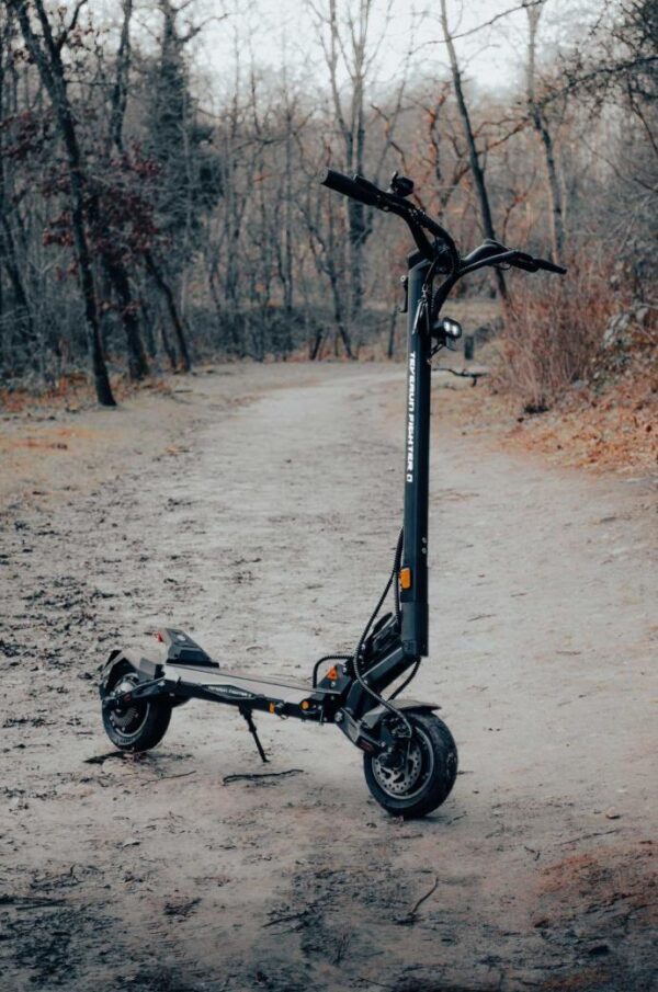 Teverun Fighter Mini Q sur un chemin de terre, trottinette électrique dépliée Teverun Fighter Mini Q sur un chemin de terre, trottinette électrique dépliée