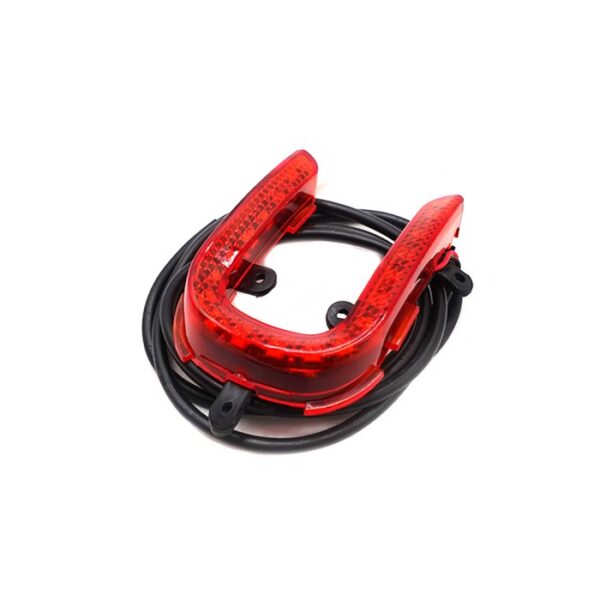 Feu arrière LED Kukirin A1 de trois quarts : lentille rouge à réflecteurs, pattes de fixation et câble enroulé