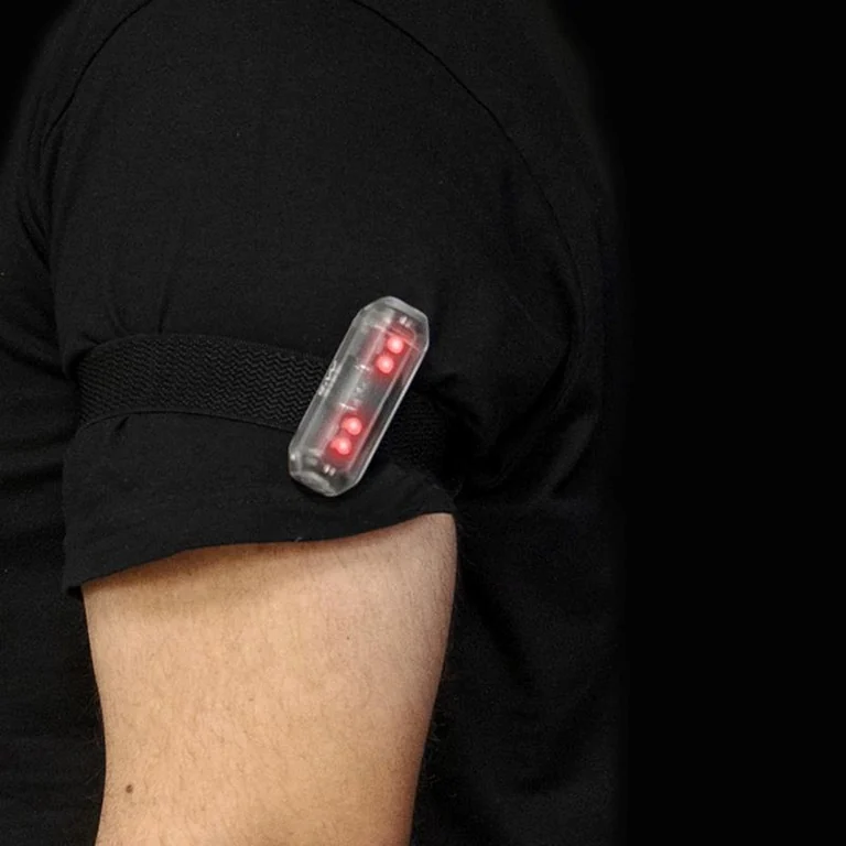 Le brassard lumineux porté au bras, ses trois LED rouges allumées
