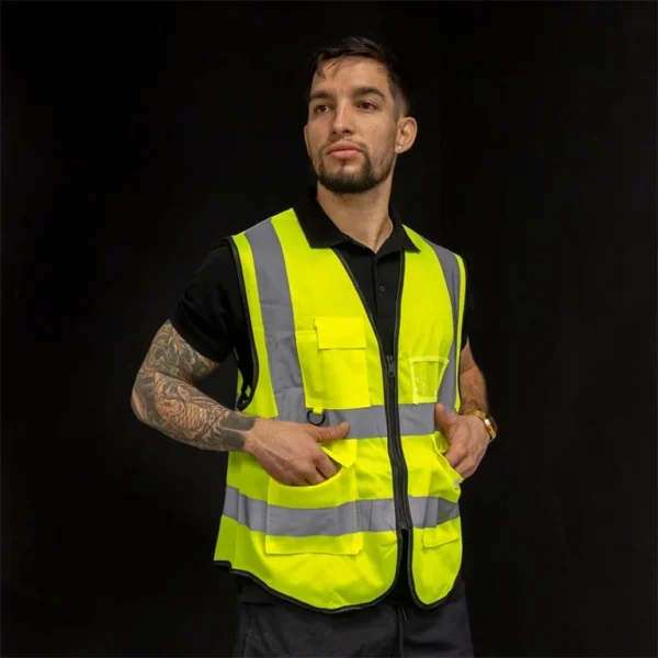 Les poches basses à rabat du gilet réfléchissant, mains à l'intérieur Les poches basses à rabat du gilet réfléchissant, mains à l'intérieur