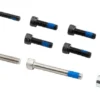 Les dix vis du kit et l'entretoise, frein-filet bleu visible sur les filets Les dix vis du kit et l'entretoise, frein-filet bleu visible sur les filets