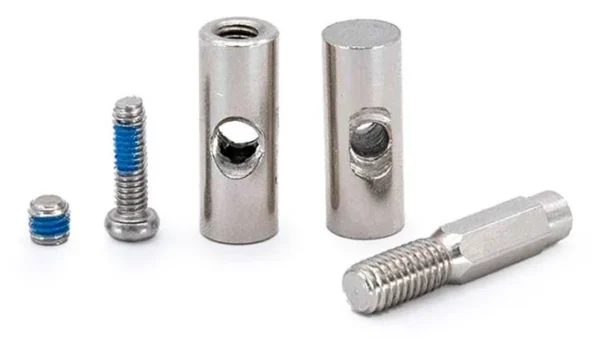 Les cinq pièces du kit : deux vis, deux écrous barillets percés et un axe fileté six pans Les cinq pièces du kit : deux vis, deux écrous barillets percés et un axe fileté six pans