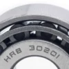 Gros plan sur la cage du cône avec le marquage 30201 gravé entre les rouleaux Gros plan sur la cage du cône avec le marquage 30201 gravé entre les rouleaux