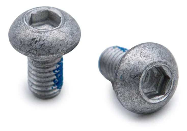 Gros plan sur deux vis de disque de frein : empreinte six pans creux et dépôt bleu de frein-filet