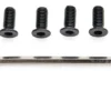 Les quatre vis noires alignées, empreintes six pans creux vers l'objectif, et la clé six pans posée en dessous.