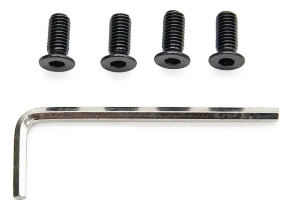Les quatre vis noires alignées, empreintes six pans creux vers l'objectif, et la clé six pans posée en dessous.