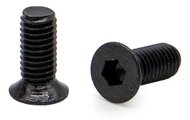 Deux vis noires de près : tête fraisée plate et empreinte six pans creux