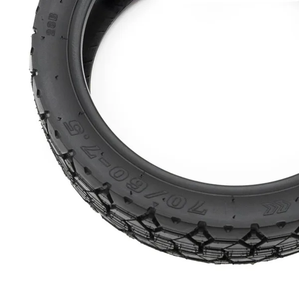 Gros plan sur la dimension 70/60-7.5 et la flèche de rotation moulées sur le flanc du pneu tubeless à crampons Gros plan sur la dimension 70/60-7.5 et la flèche de rotation moulées sur le flanc du pneu tubeless à crampons